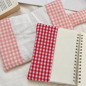 Macro detail of plaid fabric book covers showing textured cotton material and patterns