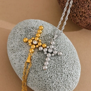 Macro view of vintage stainless steel cross necklaces with zircon on textured stones
