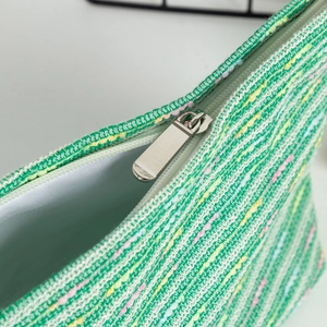 Macro detail of multi-colored woven fabric texture and high-quality silver metal zipper