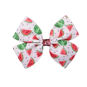 Detailed close-up of a bow hair clip featuring a fresh watermelon slice print pattern