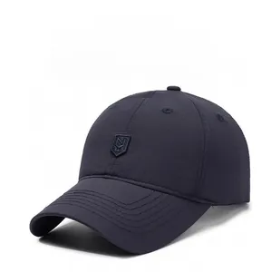 Detail of navy blue baseball cap showing breathable synthetic fabric and embroidered shield