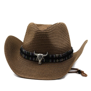 Detail of straw cowboy hat featuring ethnic band and silver bull skull ornament
