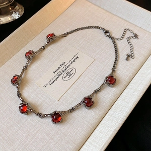 Detailed macro view of a vintage flower necklace with red gemstone in a jewelry gift box