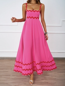 Close-up of pink maxi dress featuring vibrant red scalloped trim on neckline and waist