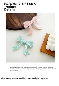Detail view of pink and mint green acetate bow hair clips with glitter line accents