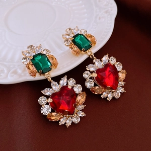 Detailed view of vintage baroque earrings with emerald-cut green and red heart gemstones