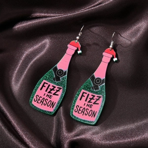 Detail of green glitter champagne bottle earrings with Fizz The Season text on silk