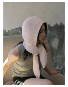 Detail of pink knitted balaclava hood with soft texture and integrated scarf for women