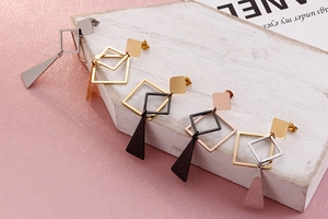 Detailed view of geometric titanium steel earrings in gold, silver, and rose gold finishes