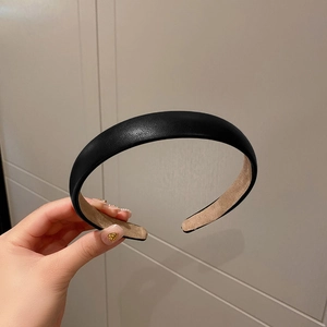 Close-up of black PU leather padded headband showing premium textured finish