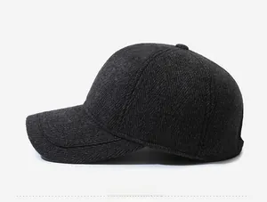 Detail view of the deep gray herringbone texture and metal sports badge on the winter cap