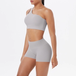 Detail of grey one-shoulder yoga bra and high-waist shorts set in moisture-wicking fabric