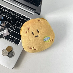 Funny yellow potato plush coin purse with happy embroidery on a desk with accessories