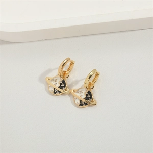 Macro detail of gold plated planet earrings with enamel filling and zircon stones