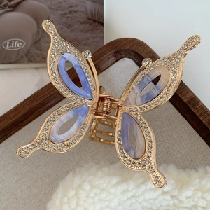 Detail view of butterfly hair claw with rhinestones and marble acetate patterns