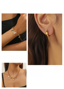 Detail of gold evil eye heart jewelry set with pink enamel and blue turquoise accents