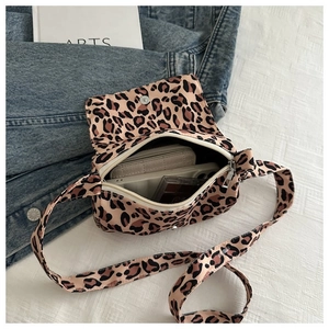 Leopard print crossbody bag with open flap showing internal capacity and daily essentials