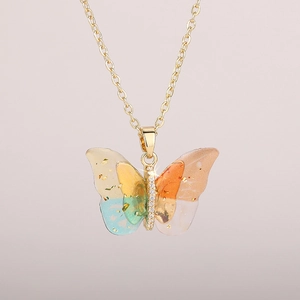 Close-up of butterfly pendant with colorful wings, gold foil, and white zircons