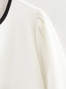Detail shot of white pleated fabric texture with black contrast collar edge stitching