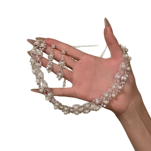 Elegant silver jewelry set with pearl necklace and diamond earrings on hand