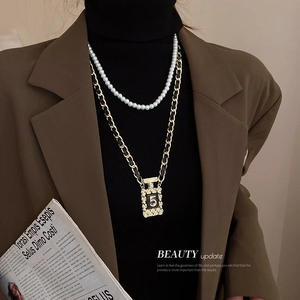 Détail d'un collier double épaisseur rétro avec pendentif bouteille de parfum