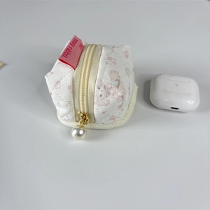 Détail de la pochette matelassée fleurie pour écouteurs avec fermeture perle