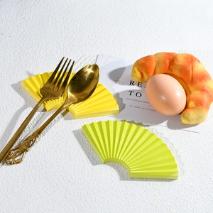Detail of fan-shaped resin display plates with wavy texture in yellow and green