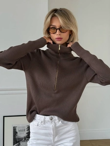 Detailed close-up of brown ribbed knit sweater featuring half-zip collar and soft texture