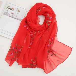 Detailed embroidery of delicate floral patterns on lightweight red chiffon sun shawl