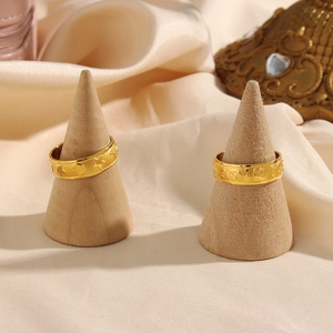 Close-up of golden sun and moon embossed rings on elegant beige satin fabric