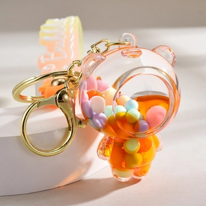 Detailed close-up of a liquid-filled bubble tea bear keychain with orange fluid and beads