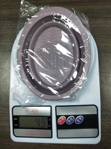 Silicone makeup brush cleaning bowl in purple weighing 49g on a digital scale