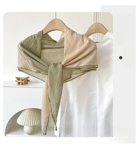 Close-up of dual-tone linen scarf with delicate lace trim on a wooden hanger