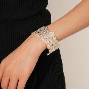 Macro detail of silver hollow clover flower bangle showing intricate metal wirework