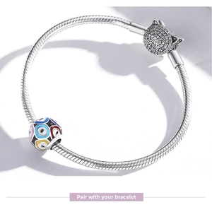 Macro view of S925 silver snake chain with crystal cat charm and colorful evil eye bead