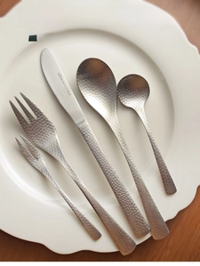 Macro detail of 304 stainless steel cutlery set with premium hammered finish texture