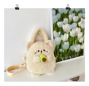 Detail of plush white cat crossbody bag holding a green avocado with cream shoulder strap