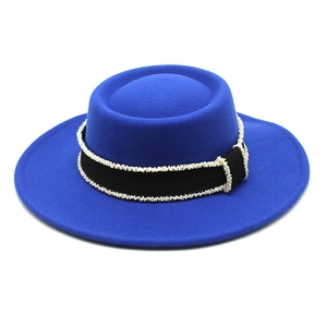 Detail of dark blue wool felt hat with black ribbon trim and white bead edge accents