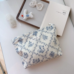 Detail of cream cotton makeup bag with blue French pattern and 'Simple Wish' label