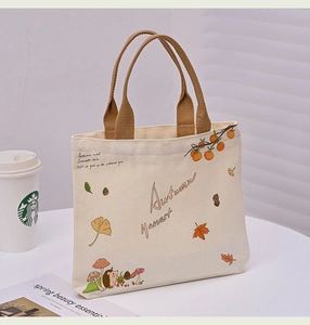 Detail of autumn canvas tote bag with hedgehog and mushroom print on white desk
