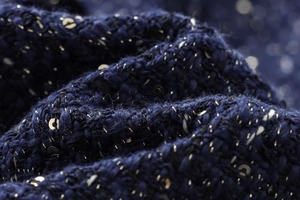 Macro detail of navy blue sequined tweed fabric showing intricate fiber texture
