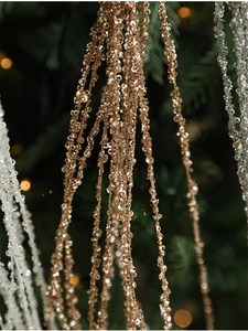 Macro-opname van champagne gouden pailletten franjes aan kerstboomtakken met bokeh effect