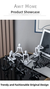 Close-up of minimalist black and white thinker sculptures on a modern desk surface