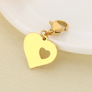 Detailed macro view of a gold-plated heart pendant with lobster clasp on textured fabric