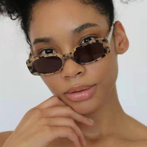 Close-up of stylish rectangular tortoise shell sunglasses on model with dark lenses
