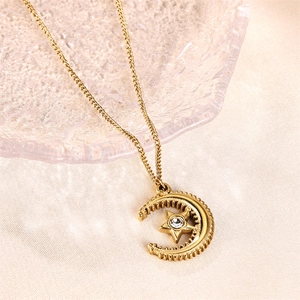 Elegant gold moon and star pendant necklace with crystal on a silk background