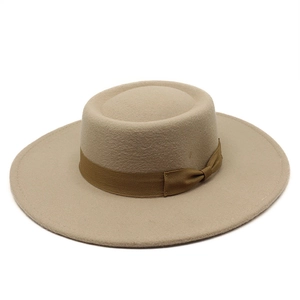 Close-up of beige wool felt flat top boater hat with a brown decorative ribbon and bow