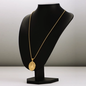 Vintage gold stainless steel religious pendant necklace on a black mannequin display