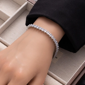 Close-up of silver tennis bracelet with square-cut cubic zirconia on a model wrist