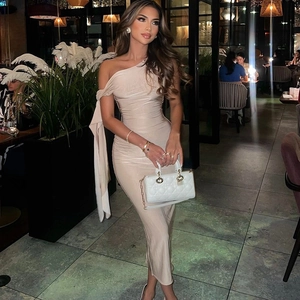 Detailed close-up of a beige one-shoulder maxi dress with elegant ruched fabric textures